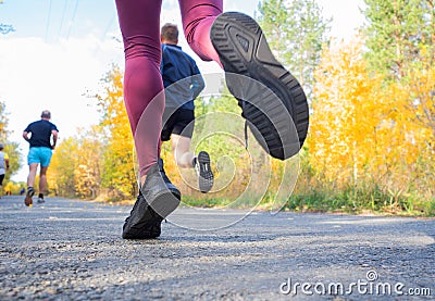 Feet of a jogger. Woman runs in the forest. Close-up of sneakers. Stock Photo