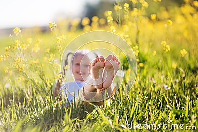 Feet of little girl in yellow field with flowers Stock Photo
