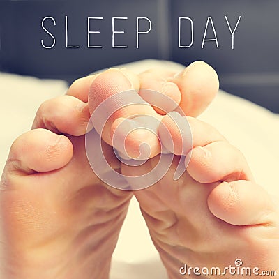 The feet of a man in bed and text sleep day Stock Photo