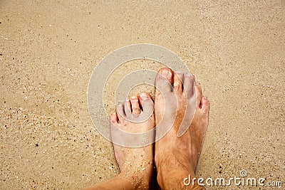 Feet of a man and his son in the fine sand surrounded by saltwater Stock Photo