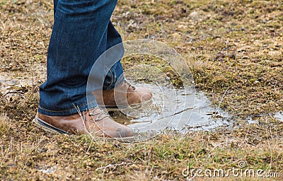 Feet of a person standing in a puddle of water Stock Photo
