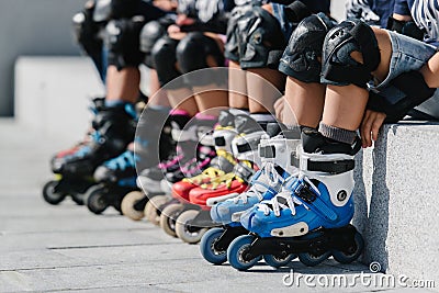 Feet of rollerbladers wearing inline roller skates sitting in outdoor skate park, Close up view of wheels befor skating Stock Photo