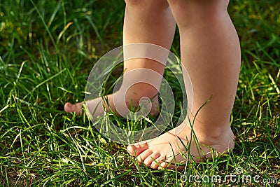 The feet of a small child on the grass, walking on bumps Stock Photo