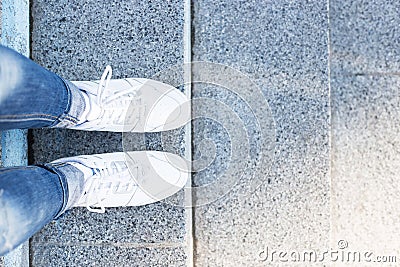 Feet in sneakers on pavement background, top view Stock Photo