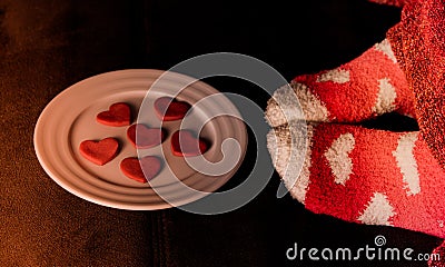 Feet in socks with hearts and cookies in shape of Stock Photo