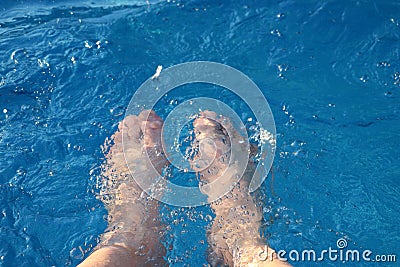 Feet submerged in water on a hot summer day. M Stock Photo