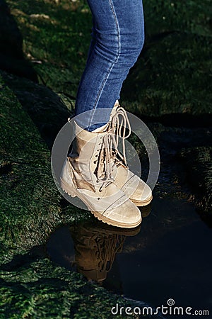Feet in unisex jeans and khaki boots on green grass nature background Stock Photo