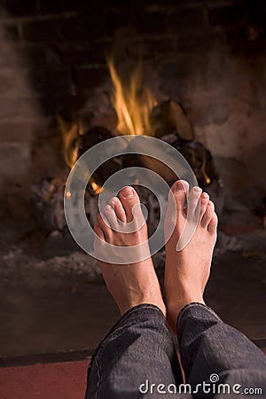 Feet warming at a fireplace Stock Photo