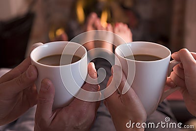 Feet warming at fireplace with coffee Stock Photo