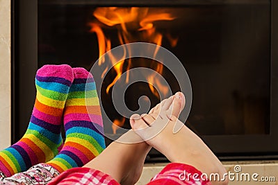 Feet warming by fireplace Stock Photo