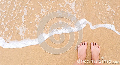 Feet of a woman on sandy beach Stock Photo