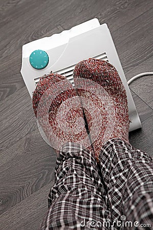 Feet with wool socks and electric heater Stock Photo