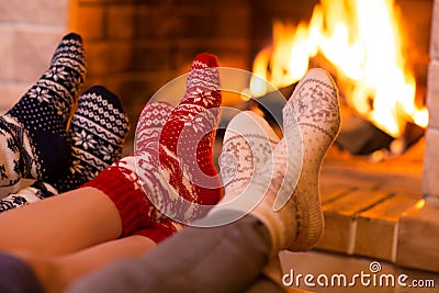 Feet in wool socks near fireplace in winter Stock Photo