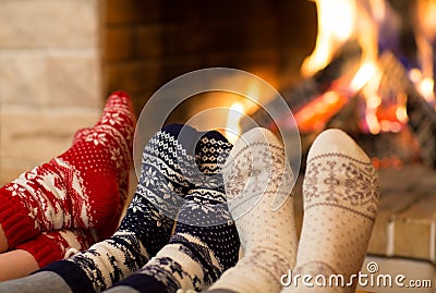 Feet in wool socks near fireplace in winter time Stock Photo