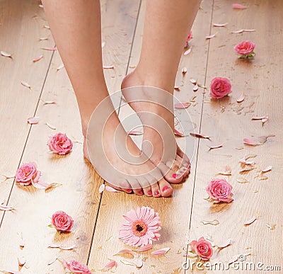 Feet of a young female on a wooden floor Stock Photo