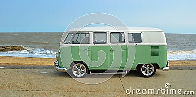 Classic Green and white VW Camper Van parked on Seafront Promenade. beach and sea in the background Editorial Stock Photo