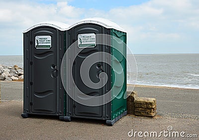 Two Portaloo cubicles on seafront promenade with the ocean in the background. Editorial Stock Photo