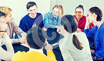 Fellow students playing guess-who game Stock Photo