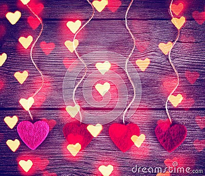 Felt fabric valentine's hearts hanging on rustic driftwood Stock Photo