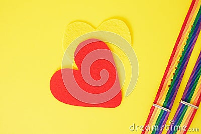 felt hearts and two bracelets with lgbt colors on yellow background copy space top view, pride concept Stock Photo