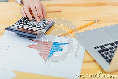 Female accountants use a calculator to sum up the amount of income, expenses, and annual statistics for summarizing Stock Photo
