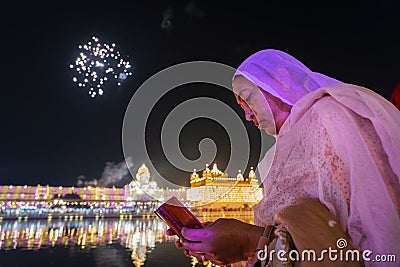 Female adult Gurunanak Devotee reading Guru Vani during the Diwali, close-up Editorial Stock Photo