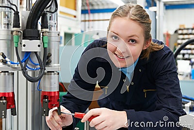 Female Apprentice Engineer Working On Machinery In Factory Stock Photo