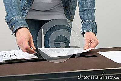 Female Architect clips some floorplans to a clipboard. Stock Photo
