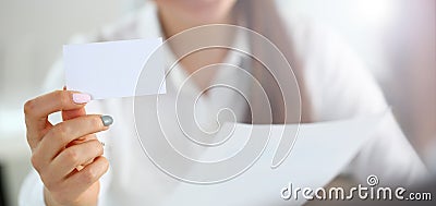 Female arm in suit give blank calling card to visitor Stock Photo