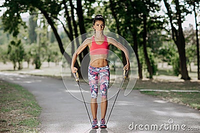 Female athlete exercising with resistance band in the park. Tough woman using a resistance band in her exercise routine. Stock Photo