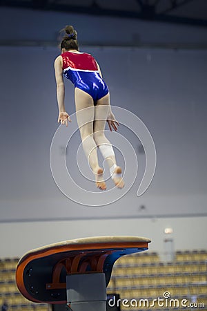 Female athlete gymnast performing a leap at the championship Editorial Stock Photo