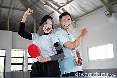 female athlete in hijab and male laughing with fists clenched Stock Photo