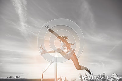 Female athlete jumping above the hurdle during the race Stock Photo