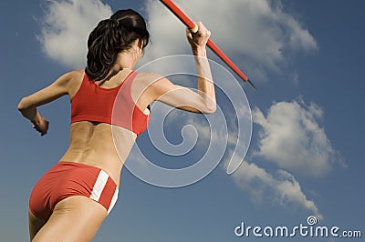 Female Athlete Throwing Javelin Against Sky Stock Photo