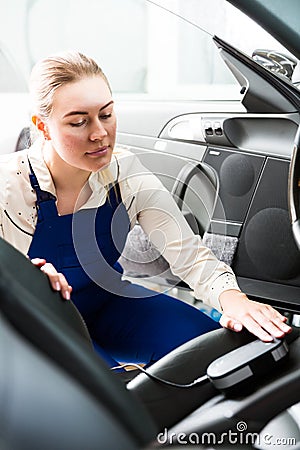 Female mechanic metering color of car upholstery Stock Photo