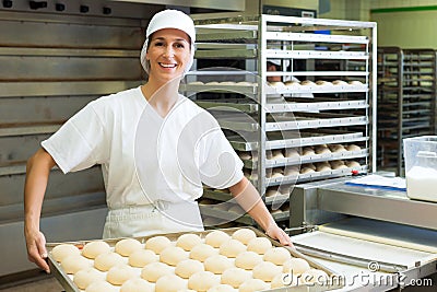 Female baker baking bread rolls Stock Photo