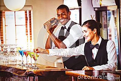 Female bartender garnishing cocktail with olive Stock Photo