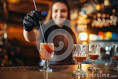 Female bartender making coctail at the bar counter Stock Photo