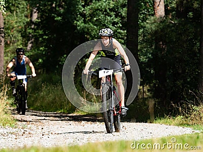 Female biker hold possition through long gravel descent in forest Editorial Stock Photo