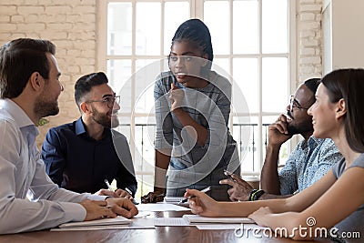 Female black executive talking to diverse employees at office briefing Stock Photo