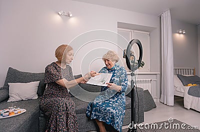 female bloggers conduct live broadcasts and broadcast on social networks. Grandmothers-bloggers communicate on the Stock Photo