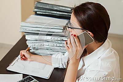 Female bookkeeper in glasses talking by phone Stock Photo