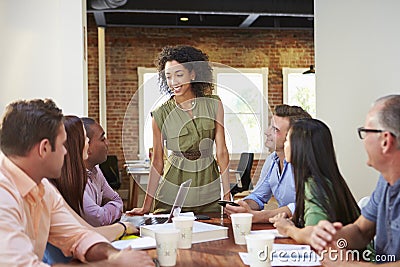 Female Boss Addressing Office Workers At Meeting Stock Photo