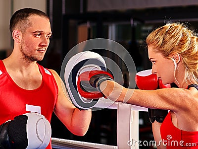 Female boxer throwing right cross at mitts Stock Photo