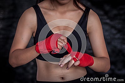 Female boxer wrapping hand for practice Stock Photo