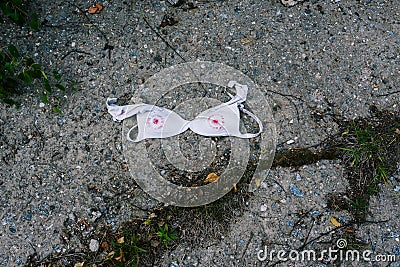 Female bra lies on the road. White bra with red lipstick. Imitation of female nipples Stock Photo