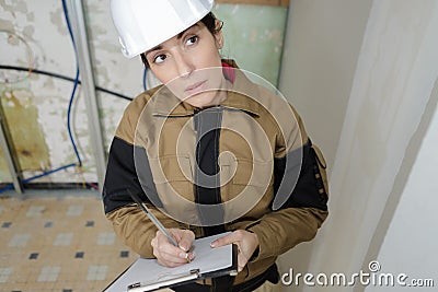 Female builder doing quotation for ceiling repair Stock Photo