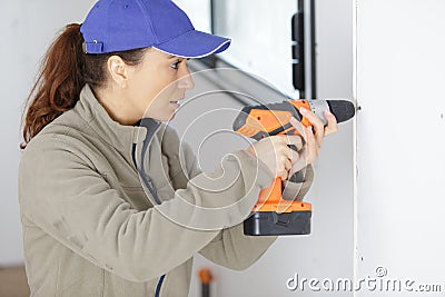 female builder drill wall Stock Photo