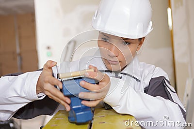 Female builder preparing sanding machine Stock Photo