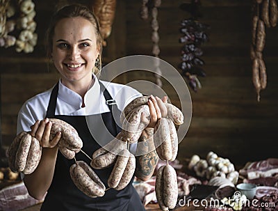 Female butcher selling sausages in shop Stock Photo